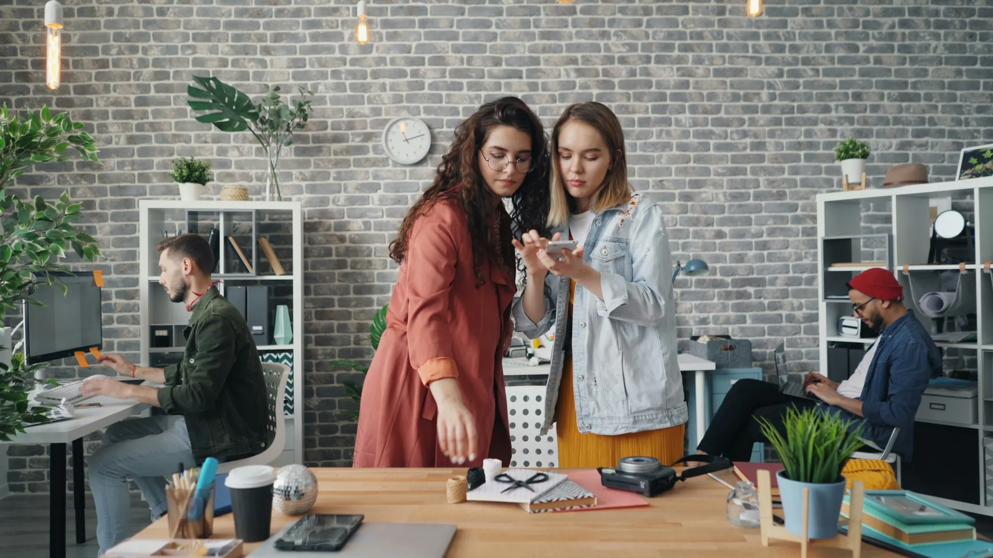 Equipe de pequena empresa atendendo clientes pelo WhatsApp no celular e no computador