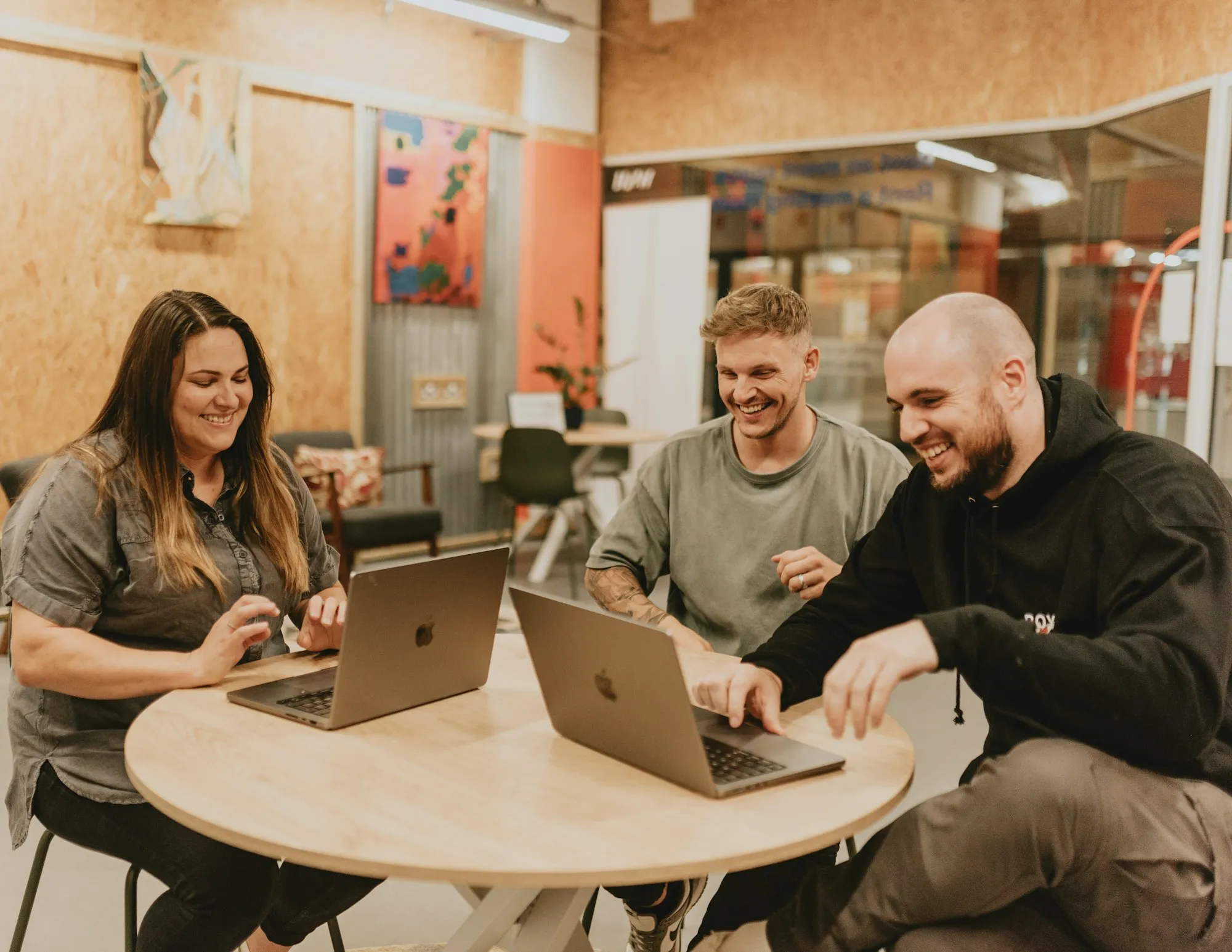 Equipe de pequena empresa trabalhando junta no escritório com notebooks e celulares