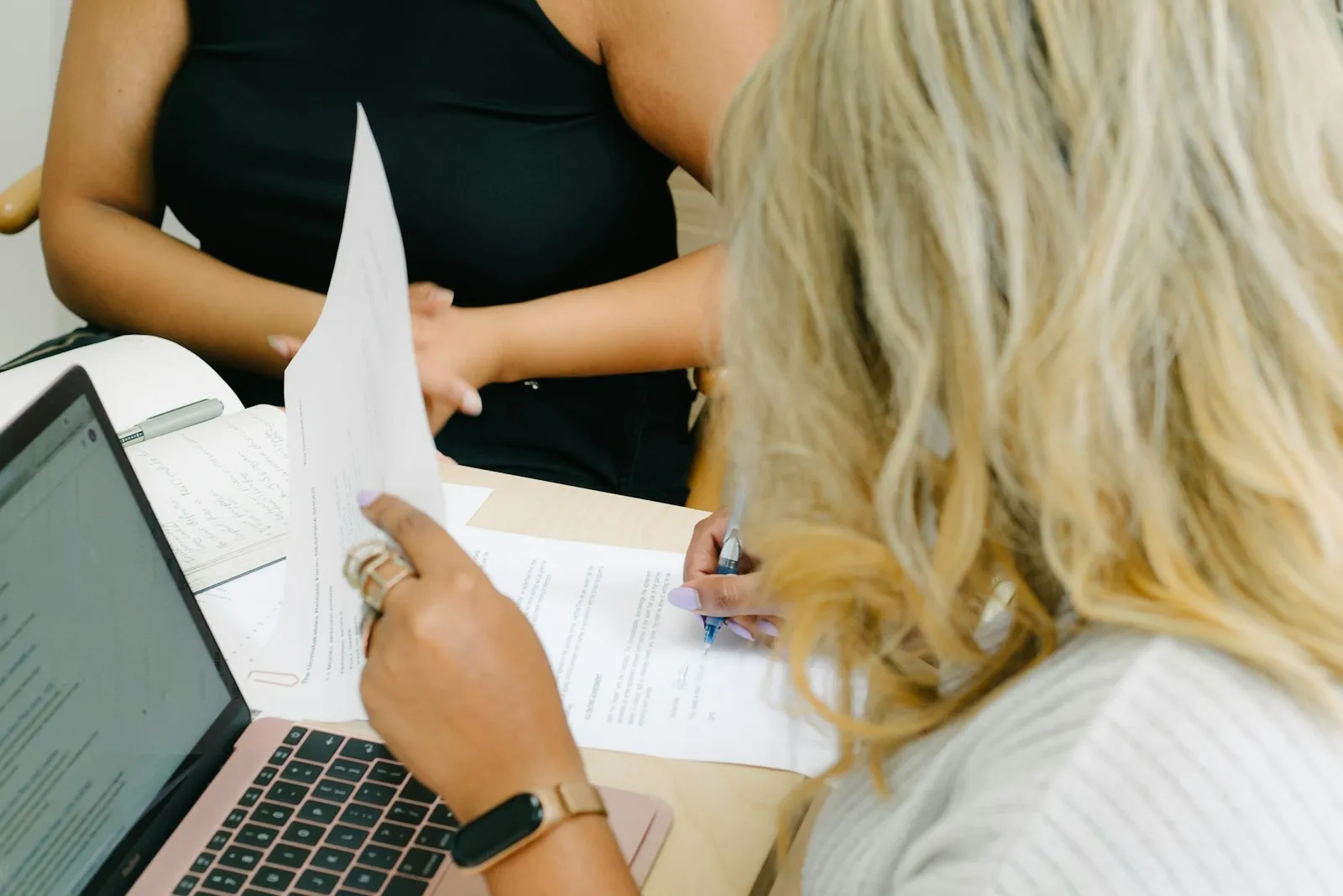 Foto: The Unmistakables / Unsplash Dona de restaurante revisa notas fiscais no computador junto com a contadora