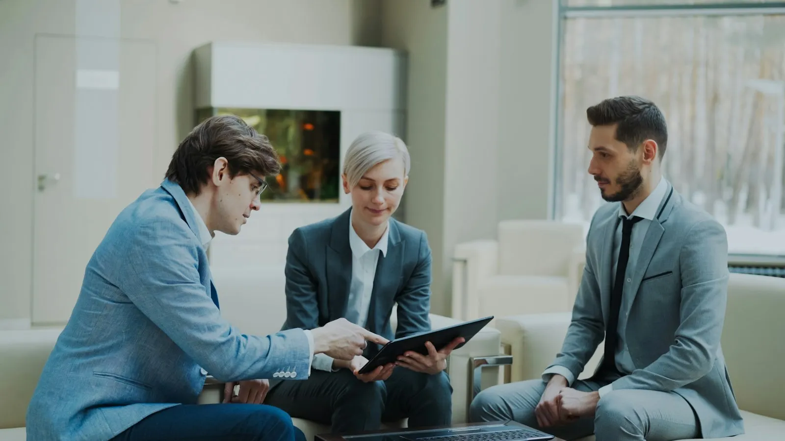 Foto: Vitaly Gariev / Unsplash Corretor de imóveis conversando com clientes e conferindo os contatos no tablet